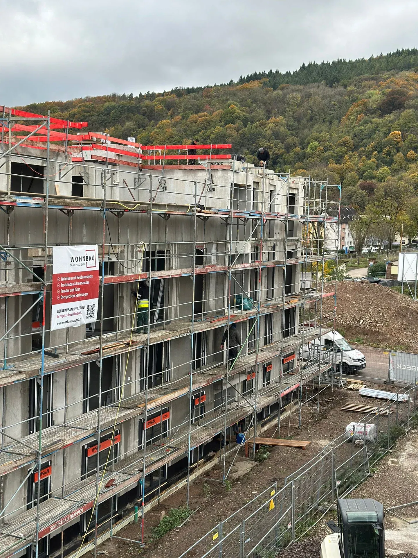 Eingerüsteter Neubau mit Bauschild der Wohnbau Saar-Pfalz GmbH
